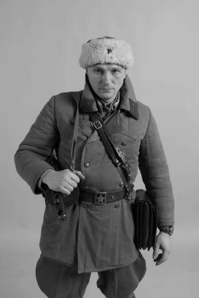 male actor in winter uniform a Russian soldier of the Red Army, a period of 1942 the second world war, posing on  background