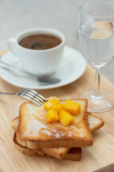 breakfast set with coffee and toasts on cutting board