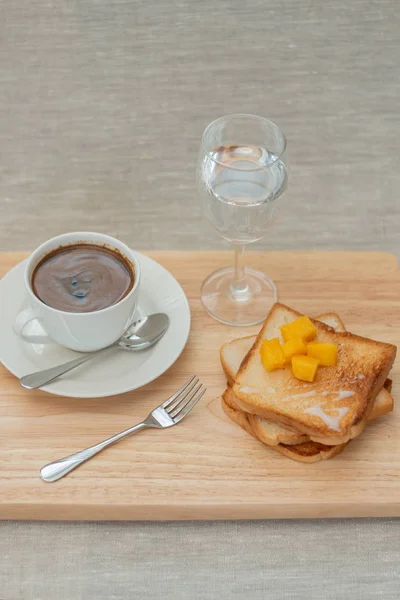 breakfast set with coffee and toasts on cutting board