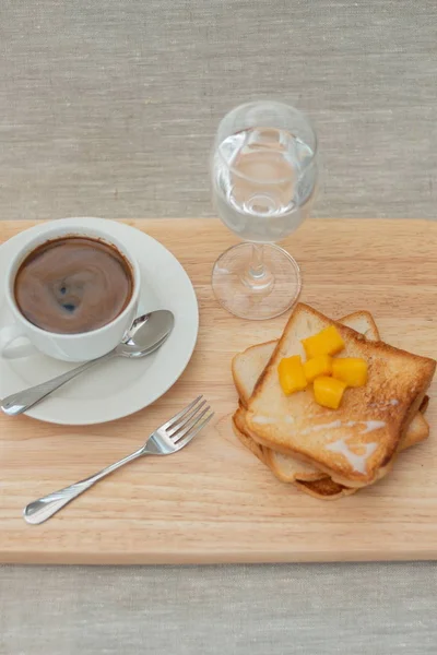 breakfast set with coffee and toasts on cutting board
