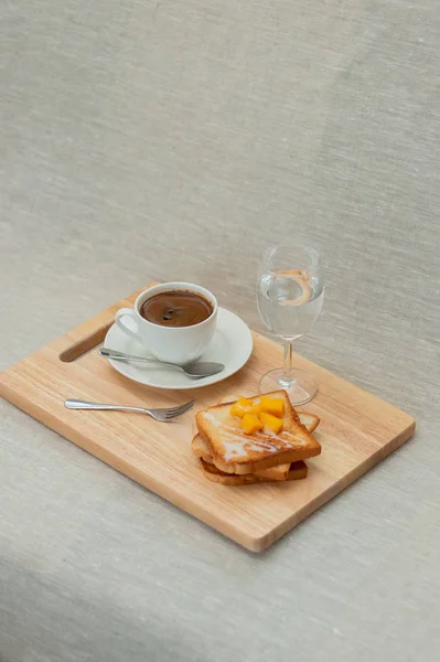 breakfast set with coffee and toasts on cutting board