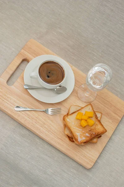 breakfast set with coffee and toasts on cutting board