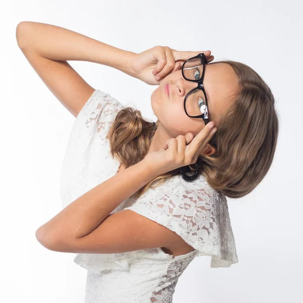 beautiful emotional girl actress in white dress with eyeglasses posing in studio on white background