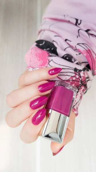 Female hand with long nails with pink nail polish