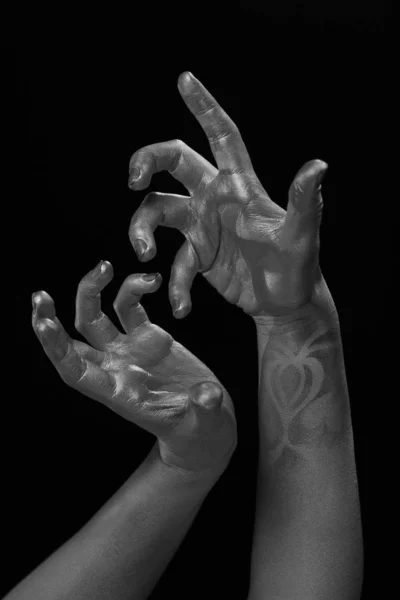Female hands body-art. Silver skin with a black pattern.