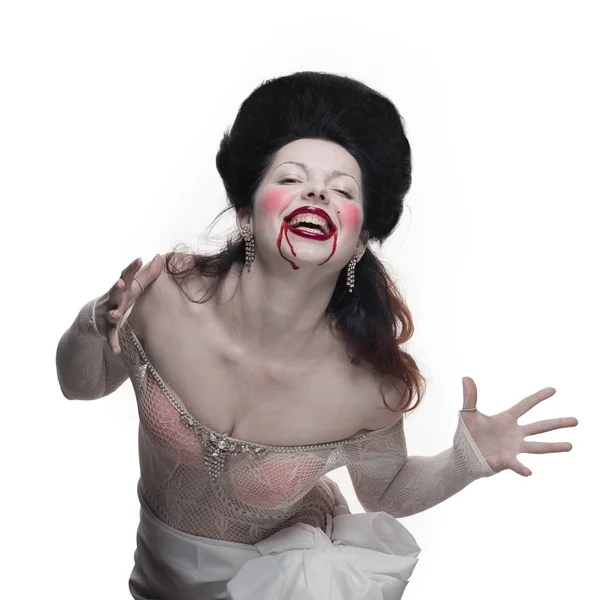 emotional actress brunette woman with pale skin in the role of vampire victims with blood on face on a white background in studio