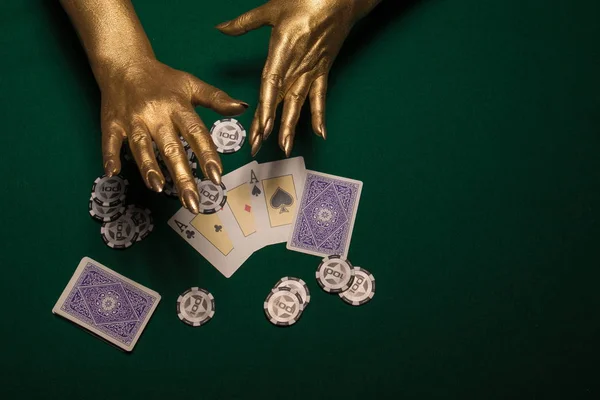 Female hands in gold paint  with cards