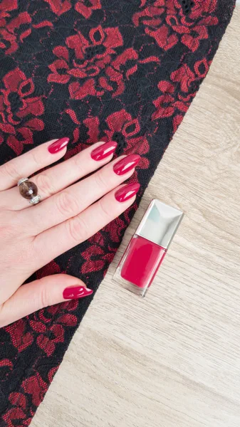 Female hand with long nails with red nail polish