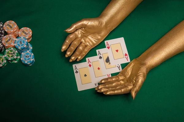 Female hands in gold paint  with cards