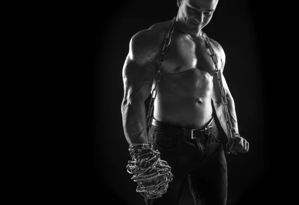 Male athlete bodybuilder posing on black background