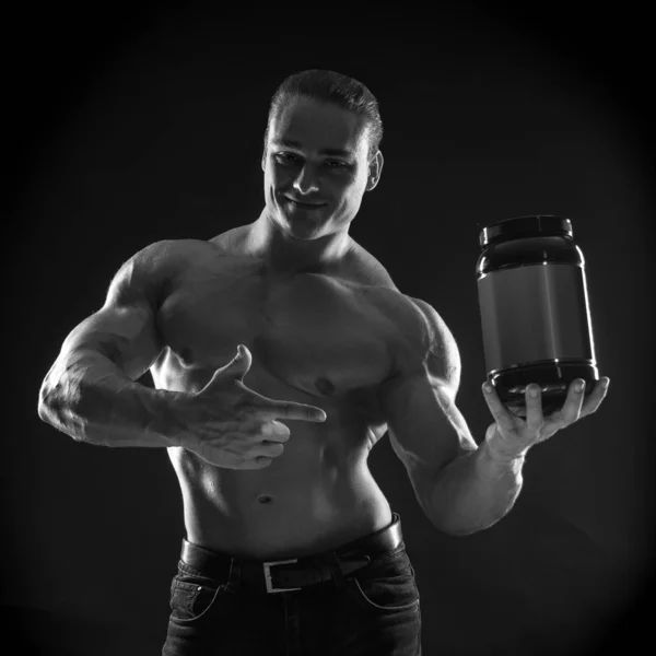 Male athlete bodybuilder posing on black background