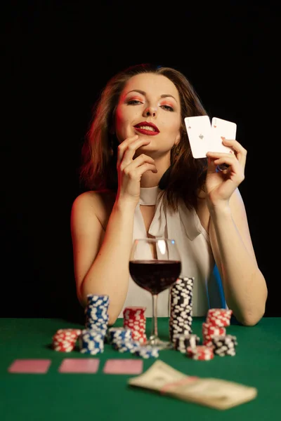 young lady in white blouse playing solitaire and posing on dark background