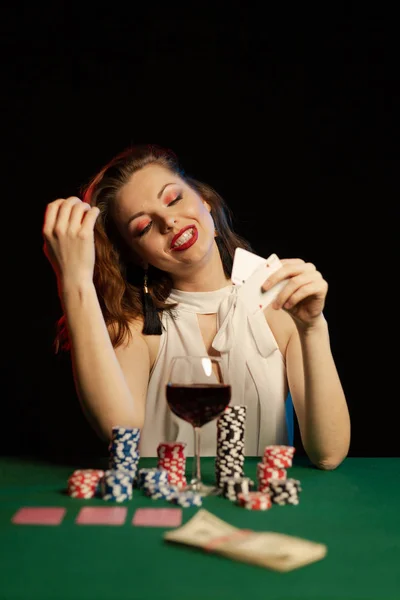 young lady in white blouse playing solitaire and posing on dark background