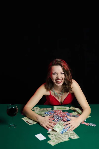 young lady in red dress playing solitaire and posing on dark background