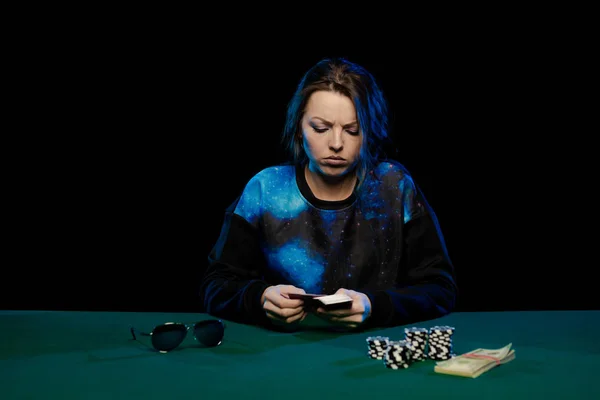 young lady playing solitaire and posing on dark background