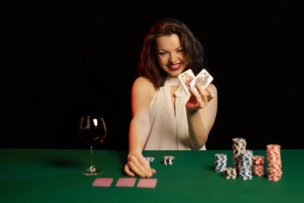 young lady in white blouse playing solitaire and posing on dark background