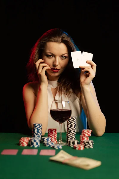 young lady in white blouse playing solitaire and posing on dark background