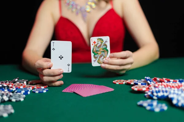 young lady in sexy dress playing solitaire and posing on dark background