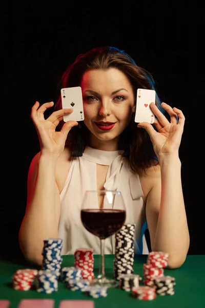 young lady in white blouse playing solitaire and posing on dark background