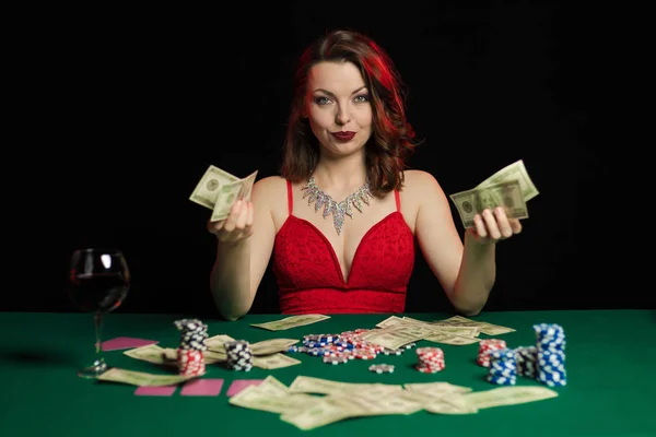 young lady in red dress playing solitaire and posing on dark background