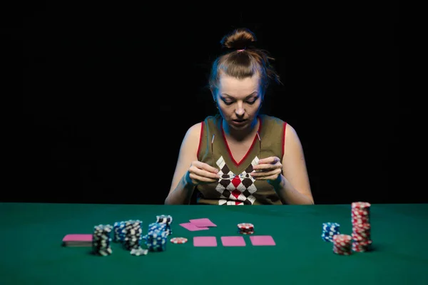 young lady playing solitaire and posing on dark background