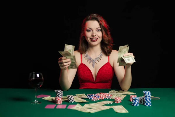 young lady in red dress playing solitaire and posing on dark background