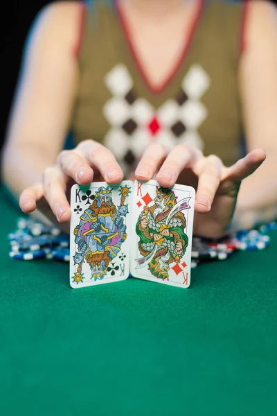 young lady playing solitaire and posing on dark background