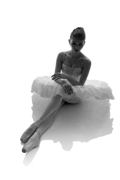 woman ballerina in white pack posing on white background, black and white photo made in the style of 