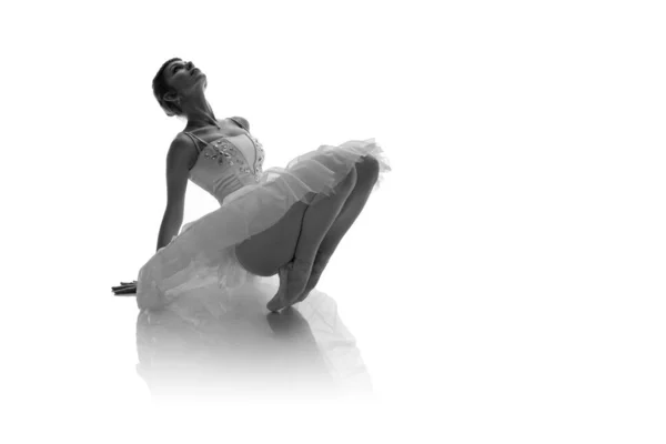 woman ballerina in white pack posing on white background, black and white photo made in the style of 