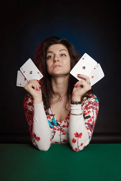actress woman playing cards in casino on dark background
