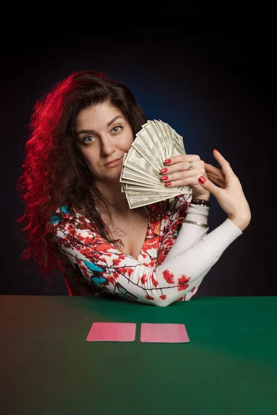 actress woman playing cards in casino on dark background