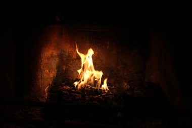 Alevler içinde şömine içinde diz çökmüş dua