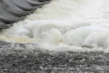 Kış köründe akan nehirdeki buz soğuk su sıçramalarına