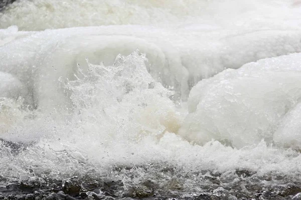 Ghiaccio spruzzi d'acqua fredda dal fiume che scorre — Foto Stock