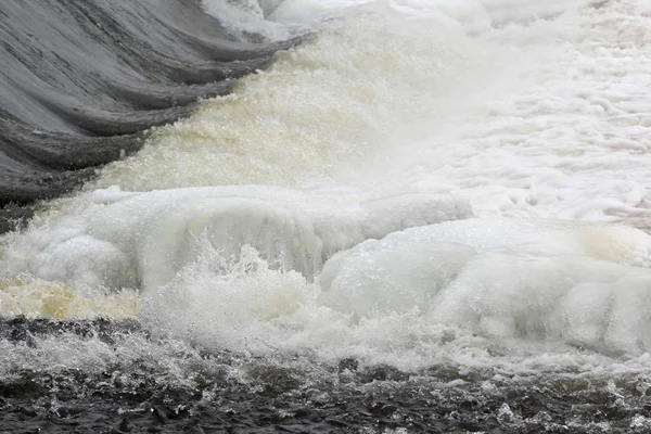 Ледяная вода льется из текущей реки — стоковое фото