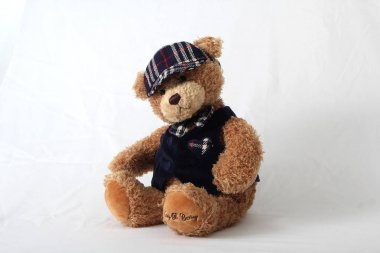 Beyaz nötr arka planda sevimli doldurulmuş oyuncak ayı