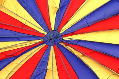 Sıcak hava balonu çeşitli renk ve çizgilere sahip kumaş desenleri şişirirken veya uçuşun başlarken.