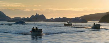 Disco Bay 'de tekneler. Gün batımında Ilulissat. Grönland.