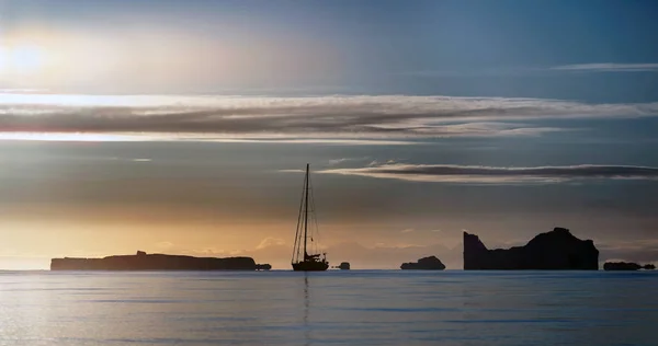 日落时帆船和冰山的剪影 格陵兰 — 图库照片