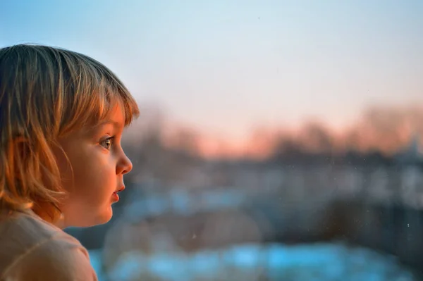 Liten Flicka Tittar Genom Fönstret Solnedgången — Stockfoto