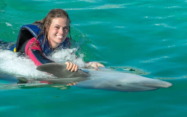 Uśmiechnięta Kobieta Pływanie Delfinem Niebieskiej Wodzie — Zdjęcie stockowe