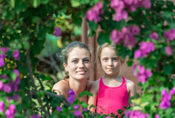 ピンクの花でかわいい小さな女の子と母 — ストック写真