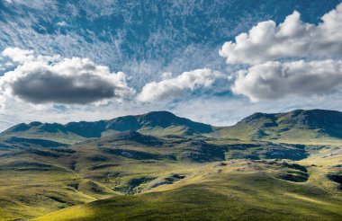 Güneşli bir günde gökyüzünde bulutlar olan dağlar. Riviersonderend Dağları manzarası. Overberg. Güney Afrika.