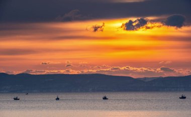 Japan fishing boats in the sea at sunrise. Against the backdrop of the island of Kunashir. Japan. The water area of Hokkaido. Kunashir Strait. Sea of Okhotsk. clipart