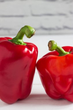 Kilolu insanlar gibi iki kırmızı biber görünüyor.