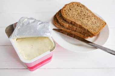 Yumuşak peynir paket bıçak beyaz arka plan açık.