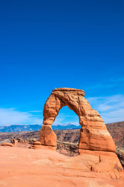 Delicate arch in arches national park with blue sky, vertical.