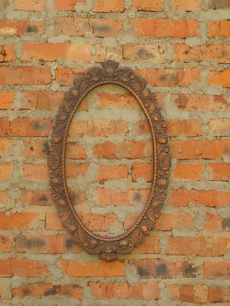 Cadre ovale en bronze sur le fond d'un vieux mur de briques . — Photo