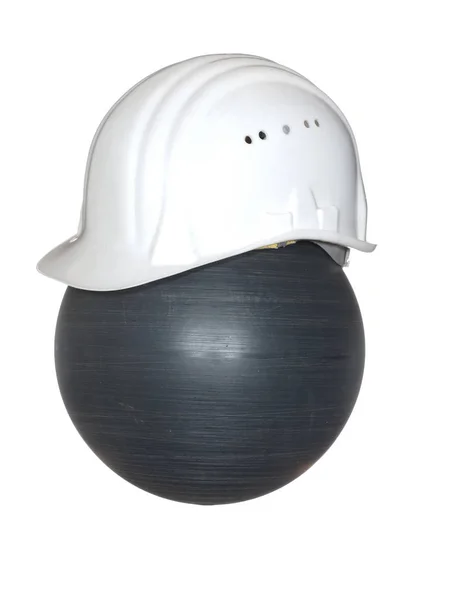 Casco di sicurezza di colore bianco su una palla nera isolata su un bianco — Foto Stock