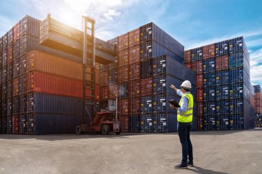 Foreman kontrol, kargo nakliye gemisinden ithalat için konteynır kutusu yüklüyor. Ustabaşı, sanayi konteynır nakliye gemisini kontrol ediyor.